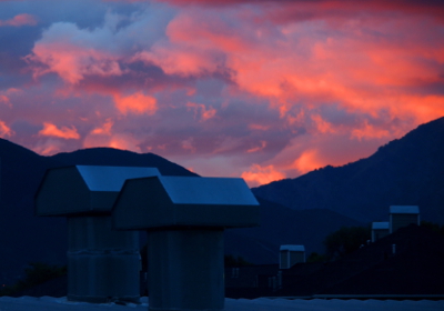 [Close in view of the purple, blue, and pink and white clouds just above the mountains.]